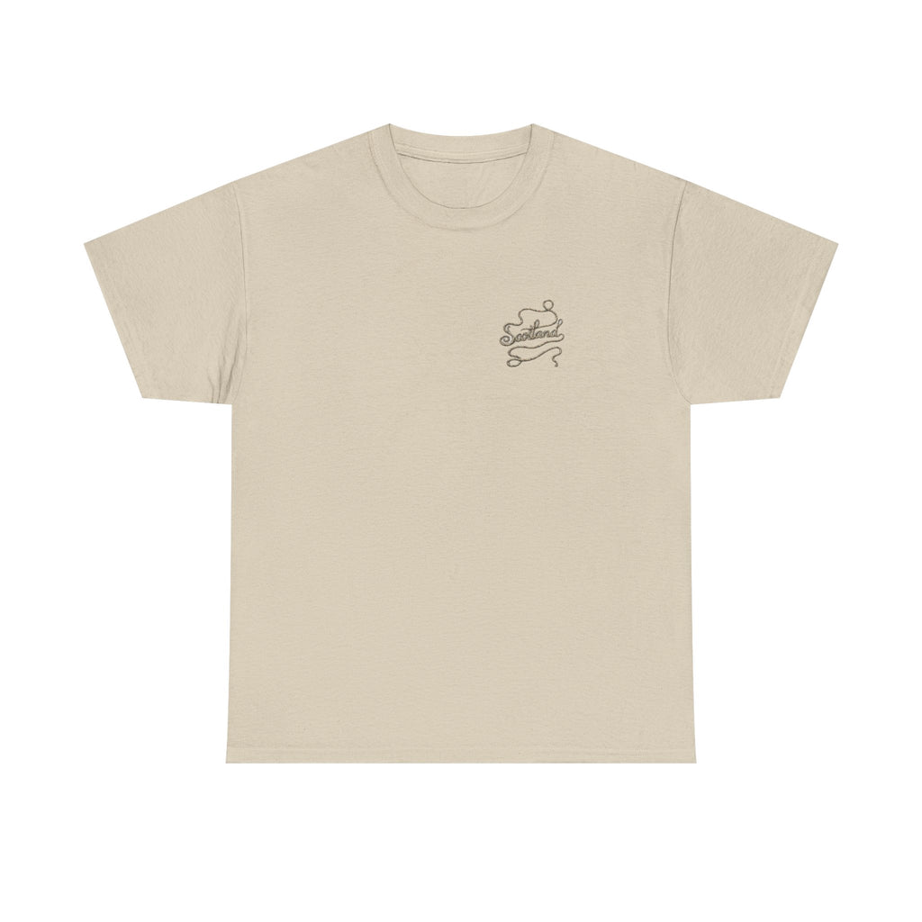 Sand Scottish Yarn t-shirt floating over a tranquil Scottish loch, featuring the clean Scottish Yarn front design by RIOTTEES.