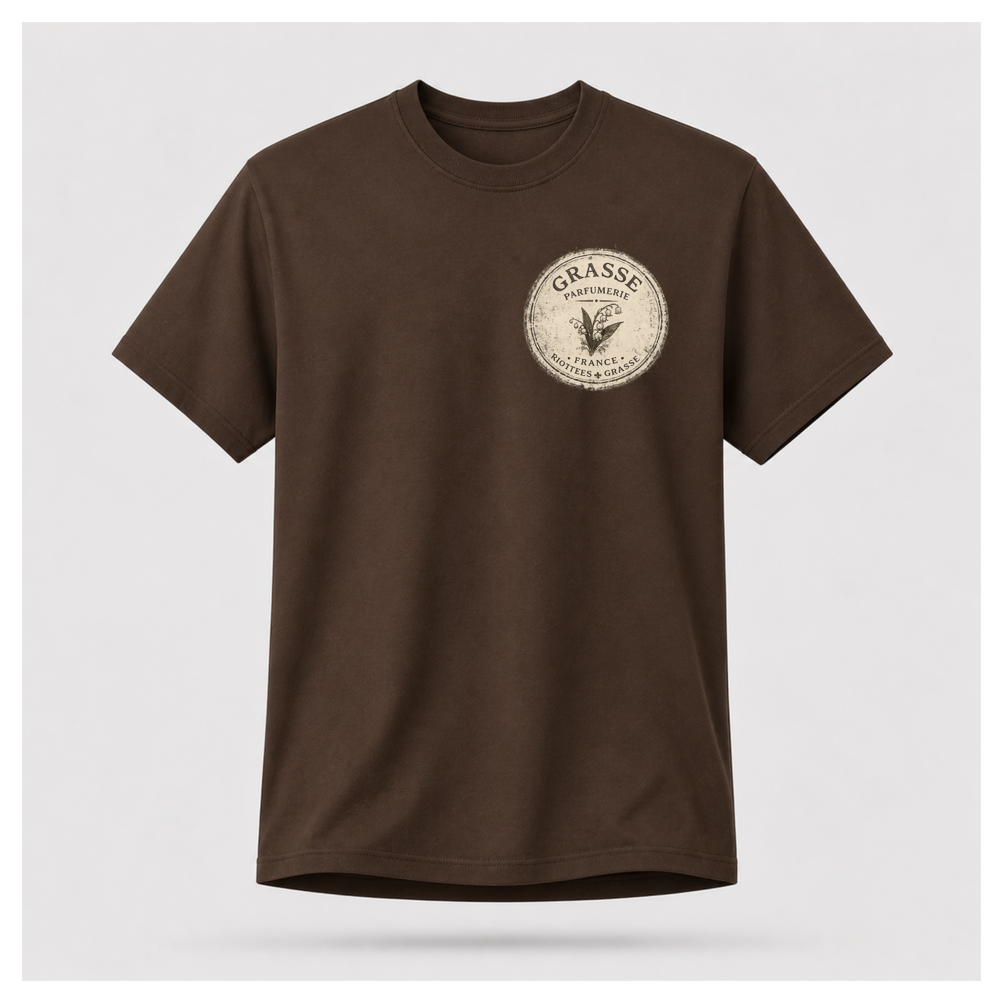 Chocolate brown Grasse Parfum Apothecary T-shirt on a floating male form, featuring the small vintage apothecary emblem front design by RIOTTEES.