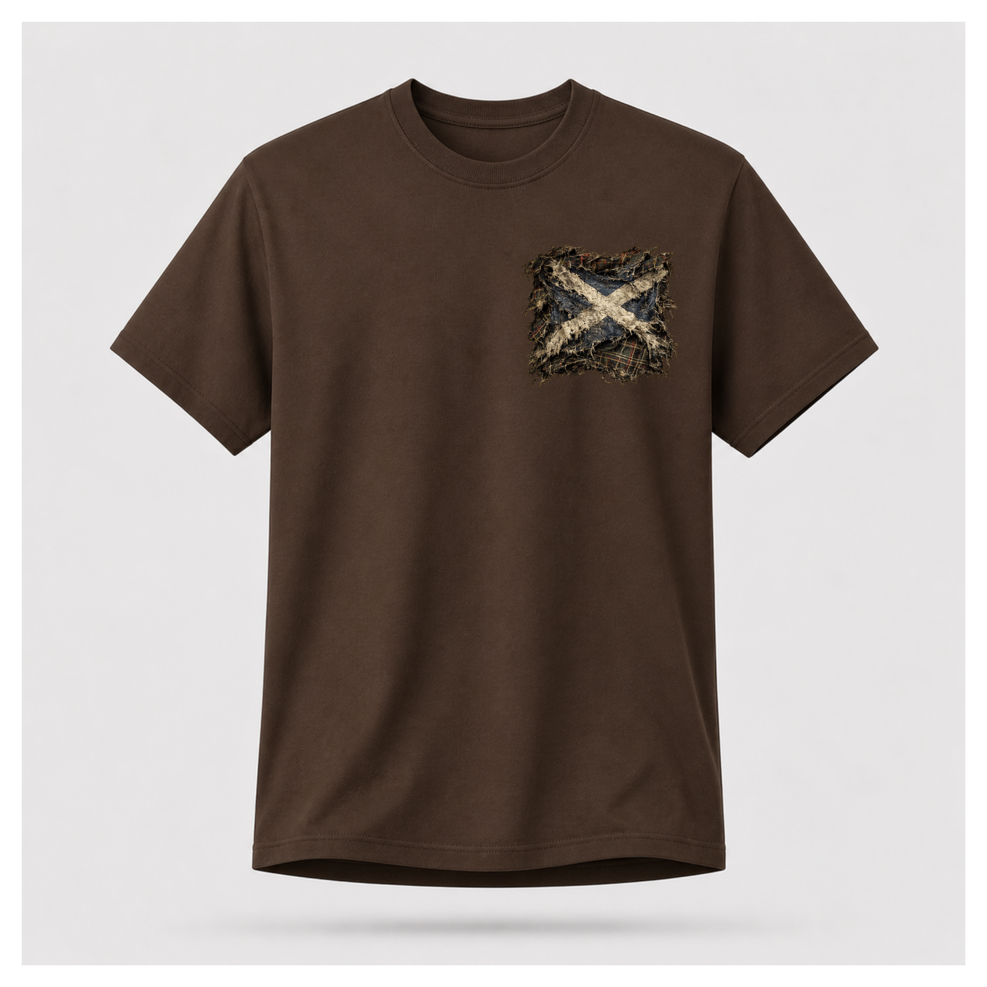 Male model wearing a chocolate brown Gildan 5000 t-shirt featuring the Modern Scotland small distressed Saltire emblem on the left chest, by RIOTTEES.
