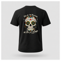 Floating men's t-shirt in black featuring a colourful Día de los Muertos sugar skull surrounded by floral folk-art details with the words "Día de los Muertos" above and "No Soul Left Behind" below, by RIOTTEES.