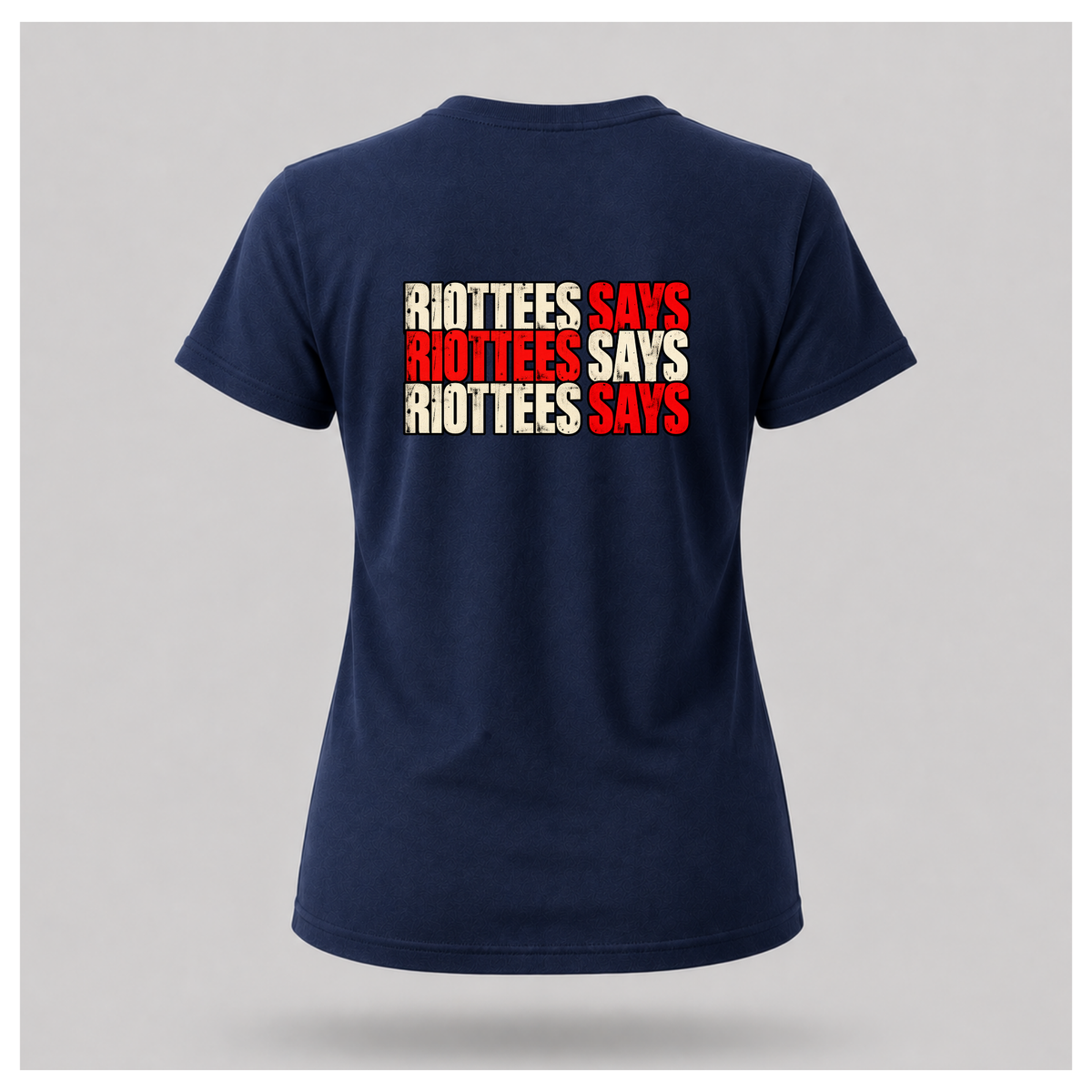 Women's navy blue RIOTTEES tee featuring the repeated RIOTTEES SAYS design across the upper back in distressed red and off-white lettering.