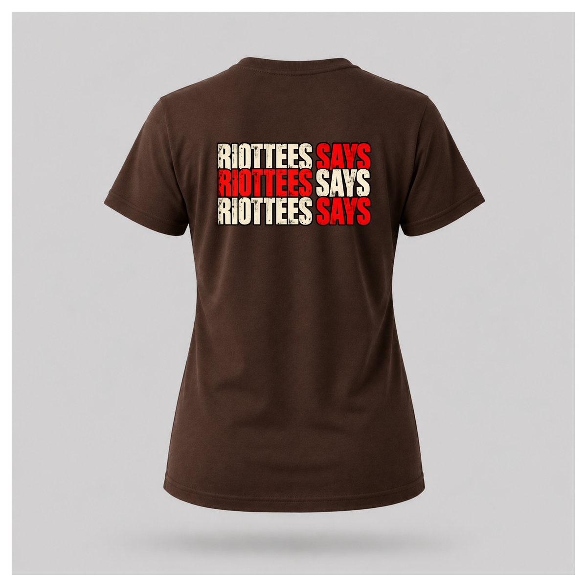 Women's chocolate brown RIOTTEES tee featuring repeated RIOTTEES SAYS typography in alternating distressed red and off-white lettering.