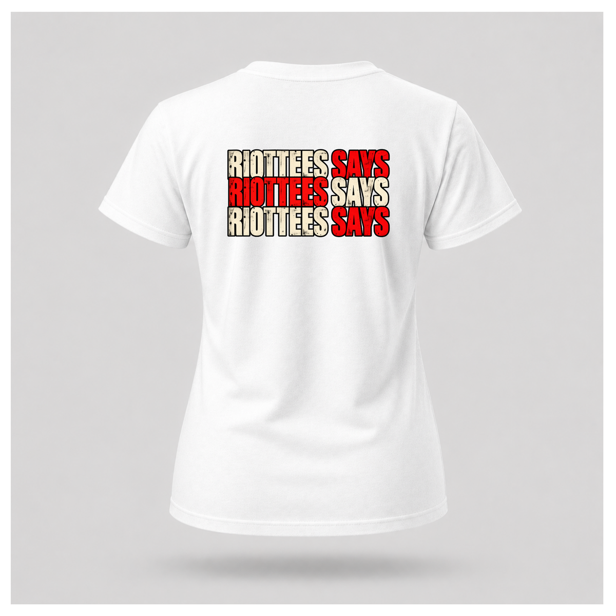 Women's white RIOTTEES tee featuring repeated RIOTTEES SAYS typography in distressed red and off-white with black outlines.