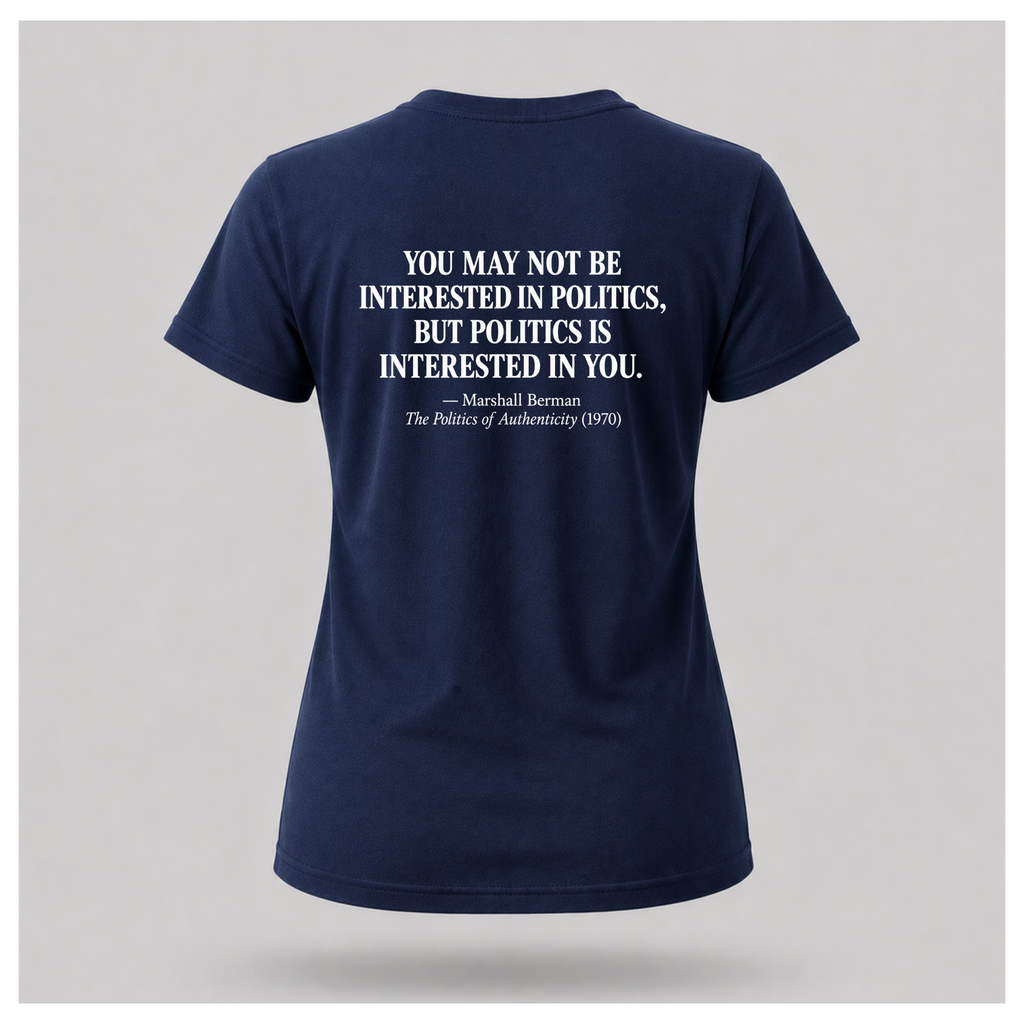 Female model wearing a navy blue Politics Is Interested In You T-shirt, showing the distressed white Marshall Berman quote on the back.