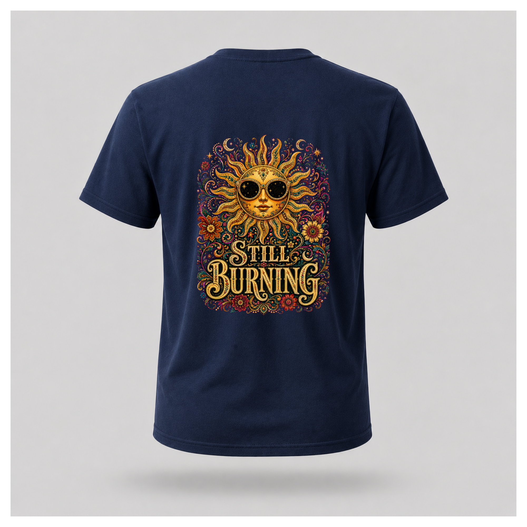 Back of a floating male form wearing the Navy Blue Still Burning Sun Spirit Tee featuring an ornate celestial sun with floral artwork and the words "Still Burning" by RIOTTEES.