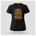 Back of a floating female form wearing the Black Still Burning Sun Spirit Tee featuring an ornate celestial sun with floral artwork and the words "Still Burning" by RIOTTEES.