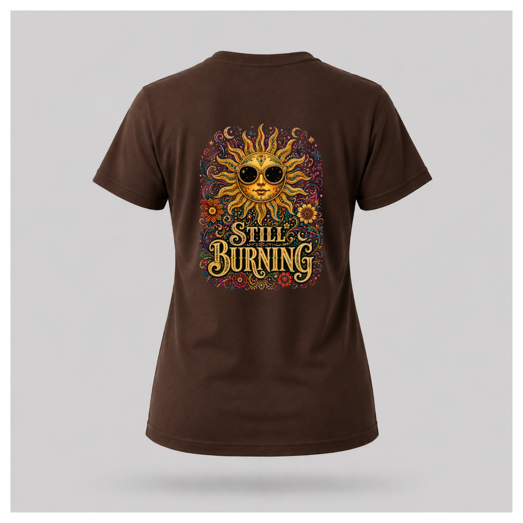 Back of a floating female form wearing the Chocolate Brown Still Burning Sun Spirit Tee featuring an ornate celestial sun with floral artwork and the words "Still Burning" by RIOTTEES.