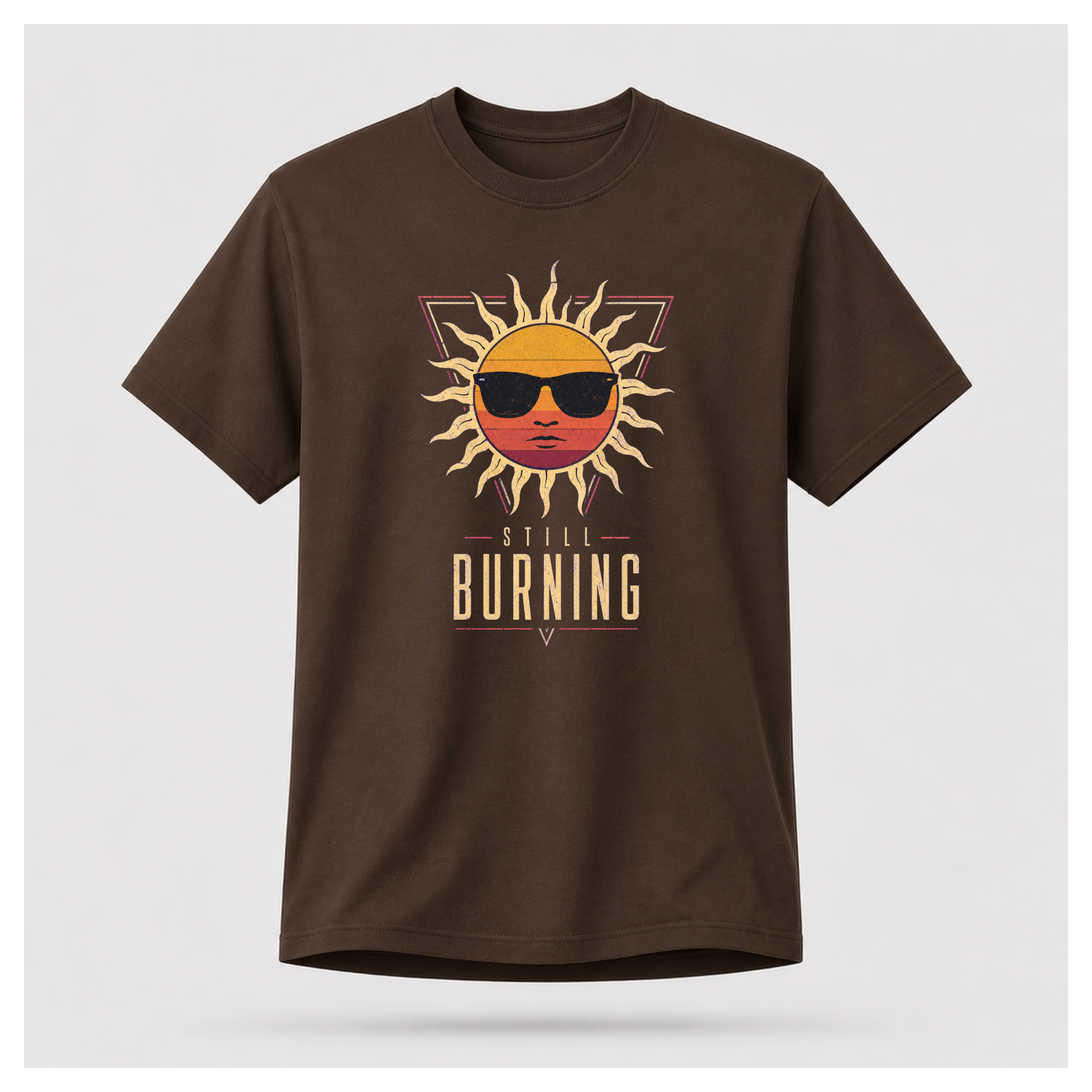 Floating male form wearing the Chocolate Brown Still Burning Sunset Prism Gildan 5000 T-shirt featuring the vintage sunset face wearing sunglasses graphic with Still Burning typography by RIOTTEES.