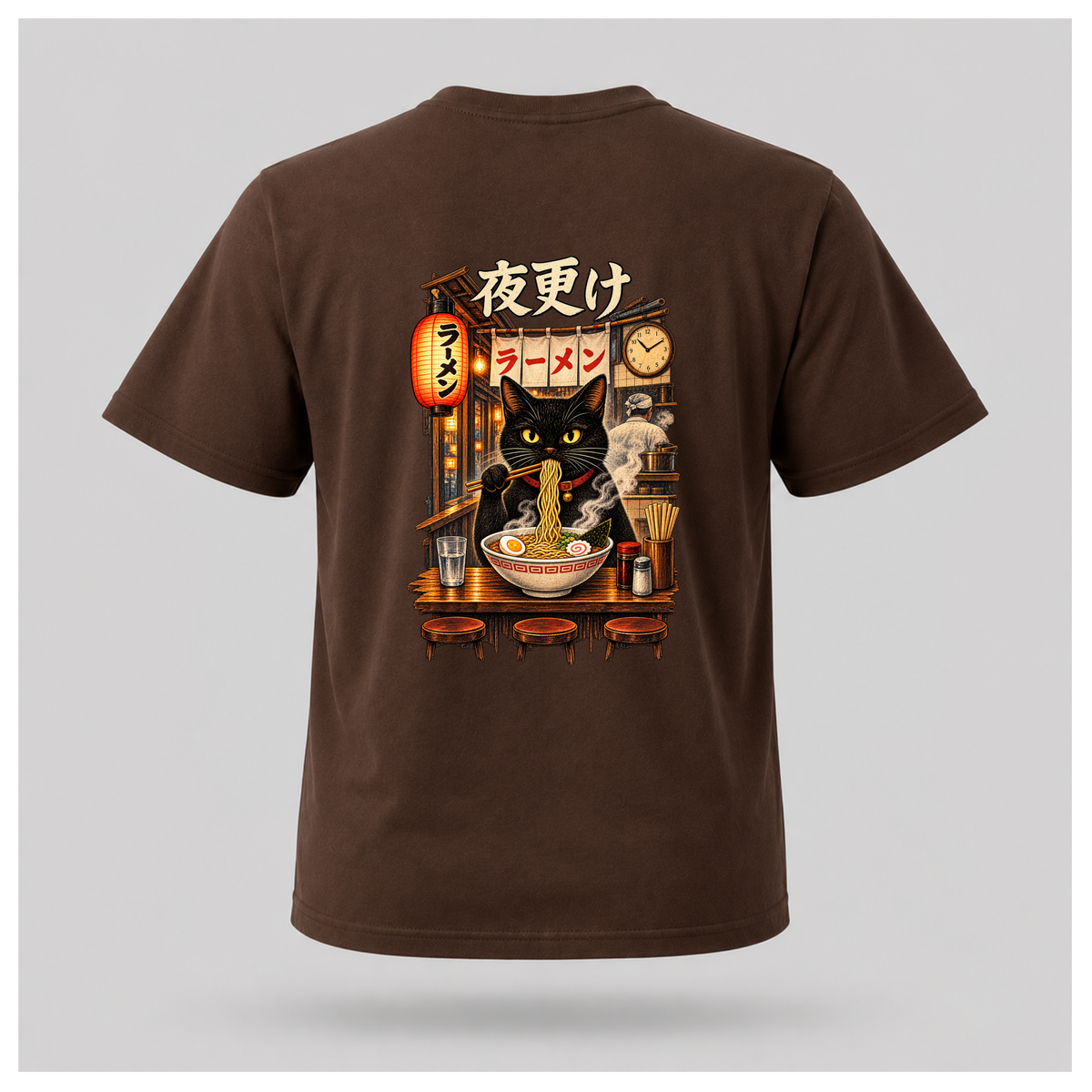 Male floating form wearing a chocolate brown Yofuke Ramen Cat graphic T-shirt, showing the large Japanese-inspired ramen cat back design by RIOTTEES.